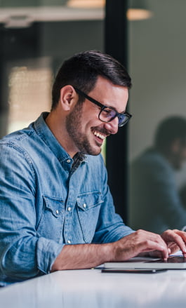 Homem branco, com cabelo curto e óculos, mexendo no notebook.